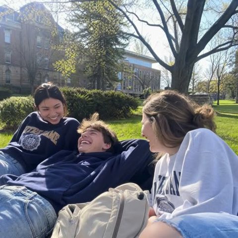 friends laughing on campus lawn